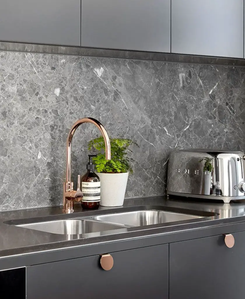 Rose gold kitchen hardware - tap and handles contrasted against dark grey cupboards, worktop and backsplash