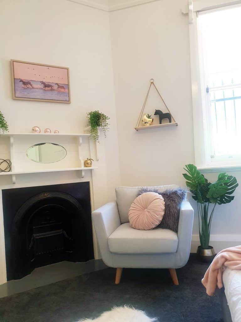 DIY Bedroom Makeover - reading corner with stylish armchair, hanging wall shelf and fireplace