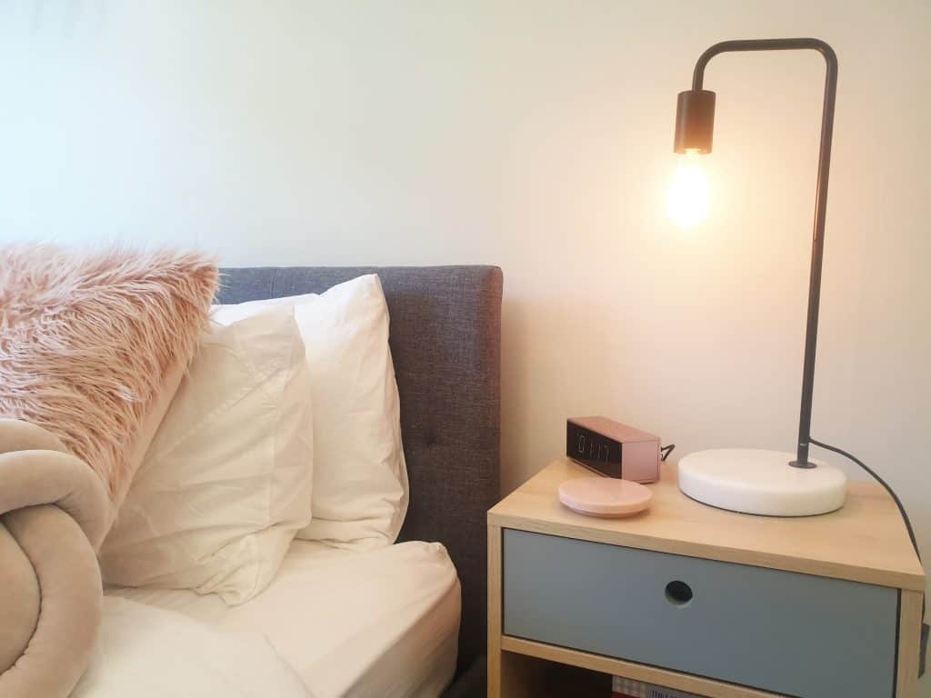 DIY Bedroom makeover - close up of bedside table with lamp and clock.