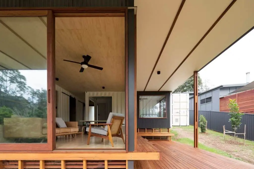 South Coast Container House living room opens up to deck area. Steel columns visible.