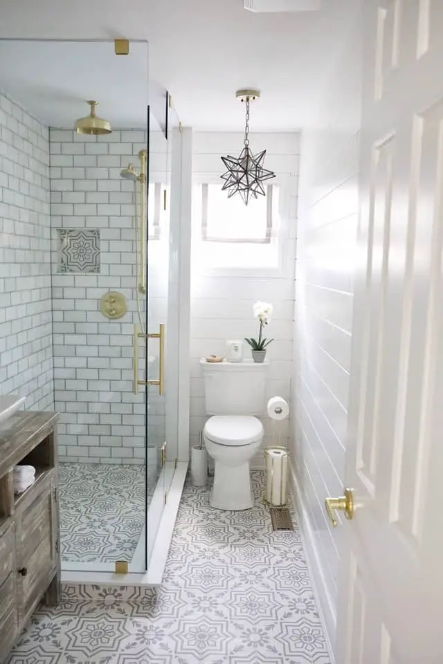 After bathroom renovation by Simply Beautiful Eating via Home Bunch. Featuring light and bright bathroom with beautiful tiles and gold fixtures.