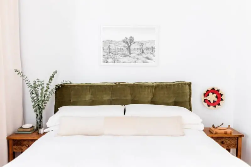 Moss green cushion hung behind bed for a headboard