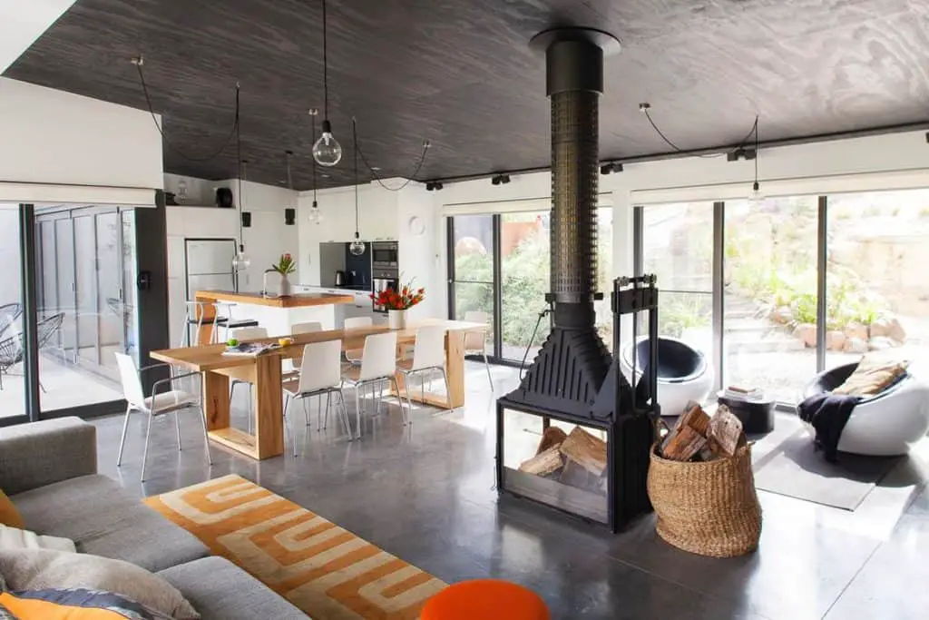 DP Toscano Architects' Daylesford shed house interior living space with wood burner and large amounts of glazing to see the landscape