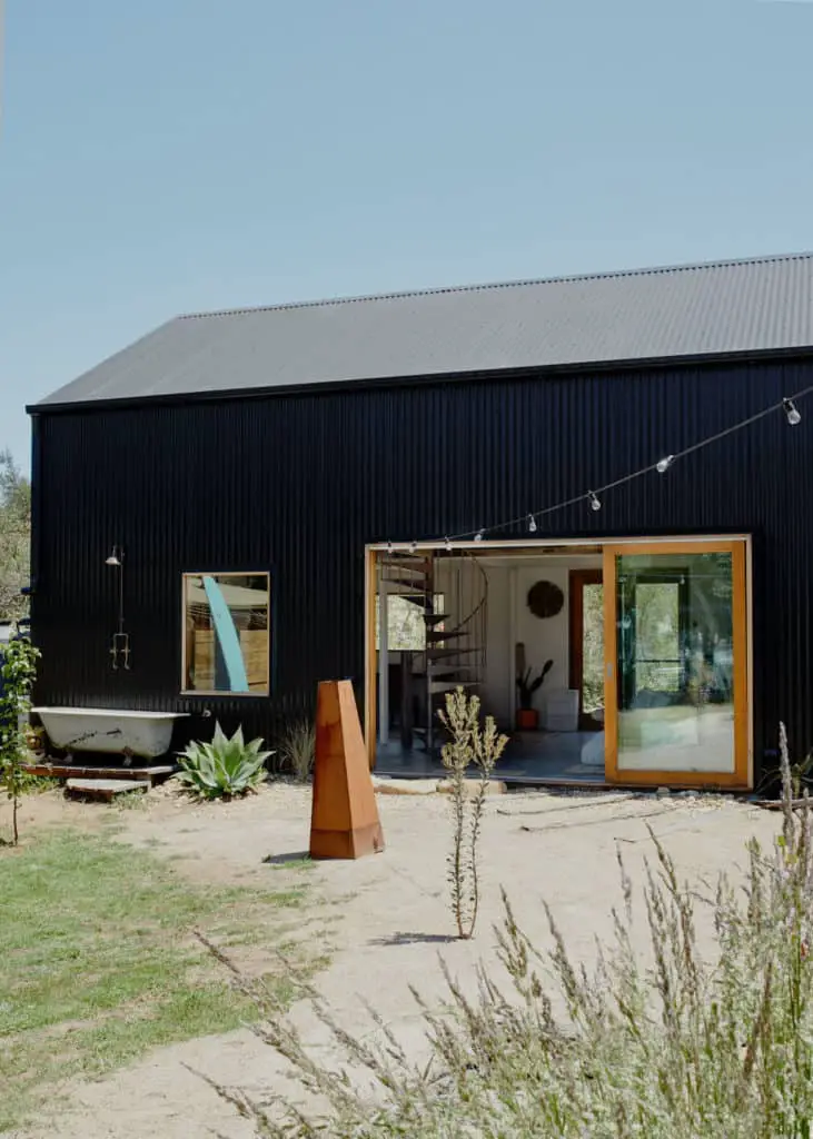 Rhys Uhllich's Shed House. Black colourbond steel cladding and recycled windows and doors