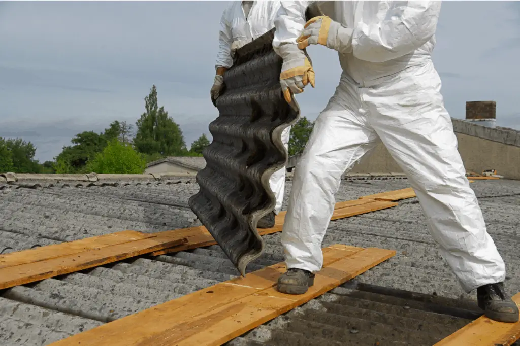 A photo of a person removing asbestos roofing sheets for a roof