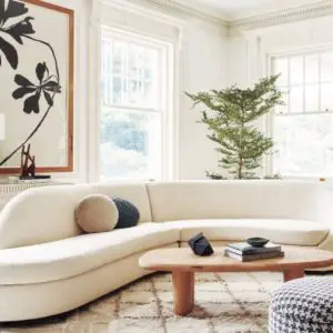 Curved sofas are a big trend for 2022. Curved white sofa in living room